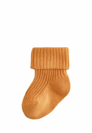 Calza arancione lavorata a maglia con bordo a coste e texture liscia. Il design presenta un colore solido e una punta arrotondata per il massimo comfort.