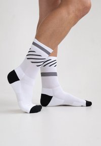 Weiße Socken mit grauen Streifen und schwarzen Akzenten; verfügen über ein strukturiertes Design sowie eine verstärkte Zehen- und Fersenpartie.