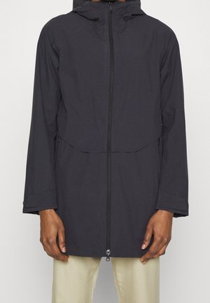 Veste de pluie bleu foncé avec capuche, fermeture éclair à l'avant et deux poches latérales. Le tissu semble lisse, avec une coupe légèrement ample et décontractée.