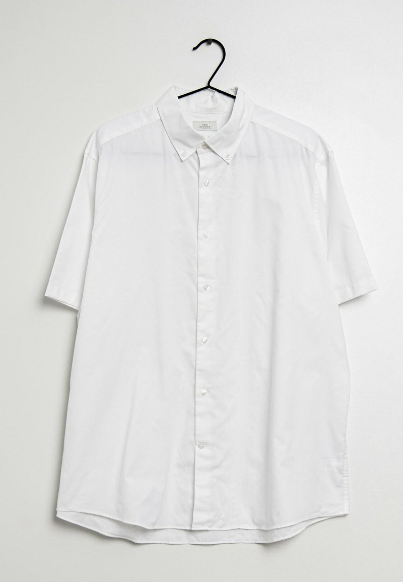 Camisa blanca de botones de manga corta con cuello, hecha de una tela ligera, con corte recto y dobladillo curvado. Incluye percha negra.
