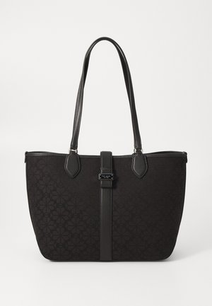 Black fabric tote bag with floral pattern, leather accents, dual straps, secure top closure, and central decorative hardware with branding.