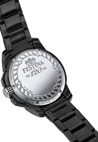Montre en acier inoxydable noir avec un boîtier rond, un cristal en saphir et du texte gravé. Équipée d'un bracelet à maillons et d'un fond métallique argenté.