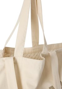 Sac fourre-tout en coton de couleur beige clair avec deux longues anses. L'intérieur présente un motif imprimé, avec des coutures visibles le long des bords.