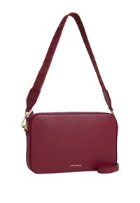 Borsa a tracolla in pelle bordeaux con finitura testurizzata, hardware dorato e una tracolla regolabile a fantasia. Dotata di chiusura superiore con zip e dettaglio del logo.