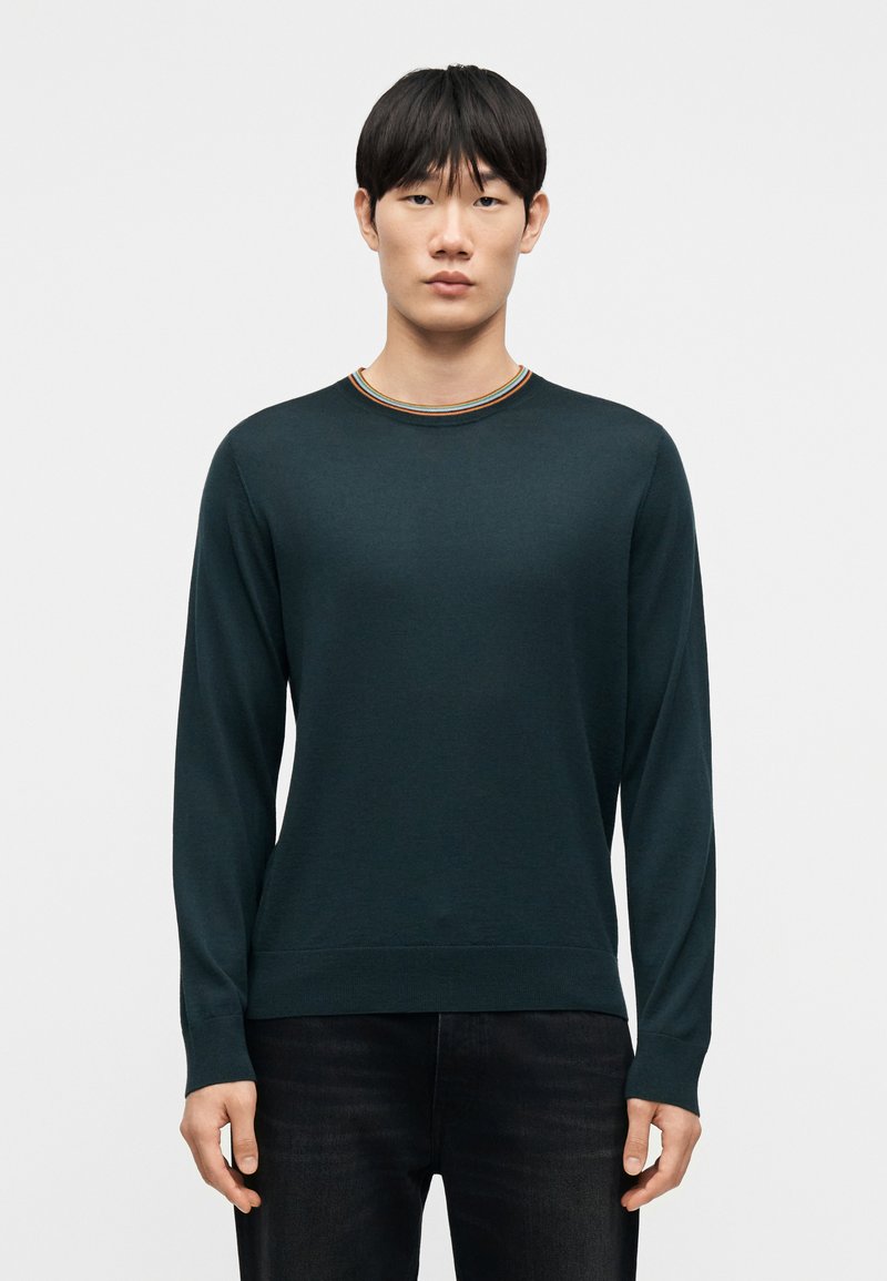 Pull vert foncé à manches longues avec un col côtelé présentant de fines rayures multicolores. Texture douce, coupe classique et sans motifs visibles.