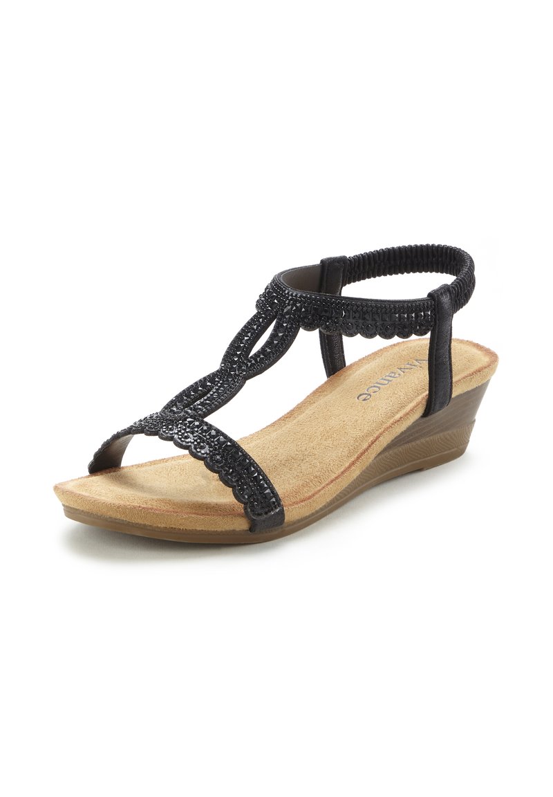 Black wedge sandal featuring decorative strap with beaded accents, cushioned tan footbed, and flexible rubber outsole for comfort.