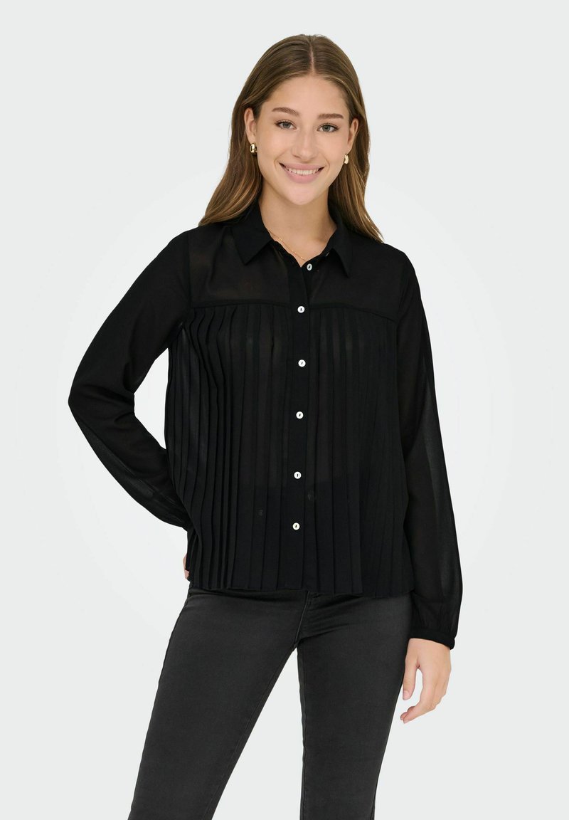 Blusa nera plissettata con chiusura a bottoni sul davanti, maniche lunghe e colletto. Caratterizzata da un materiale trasparente e bottoni bianchi decorativi.