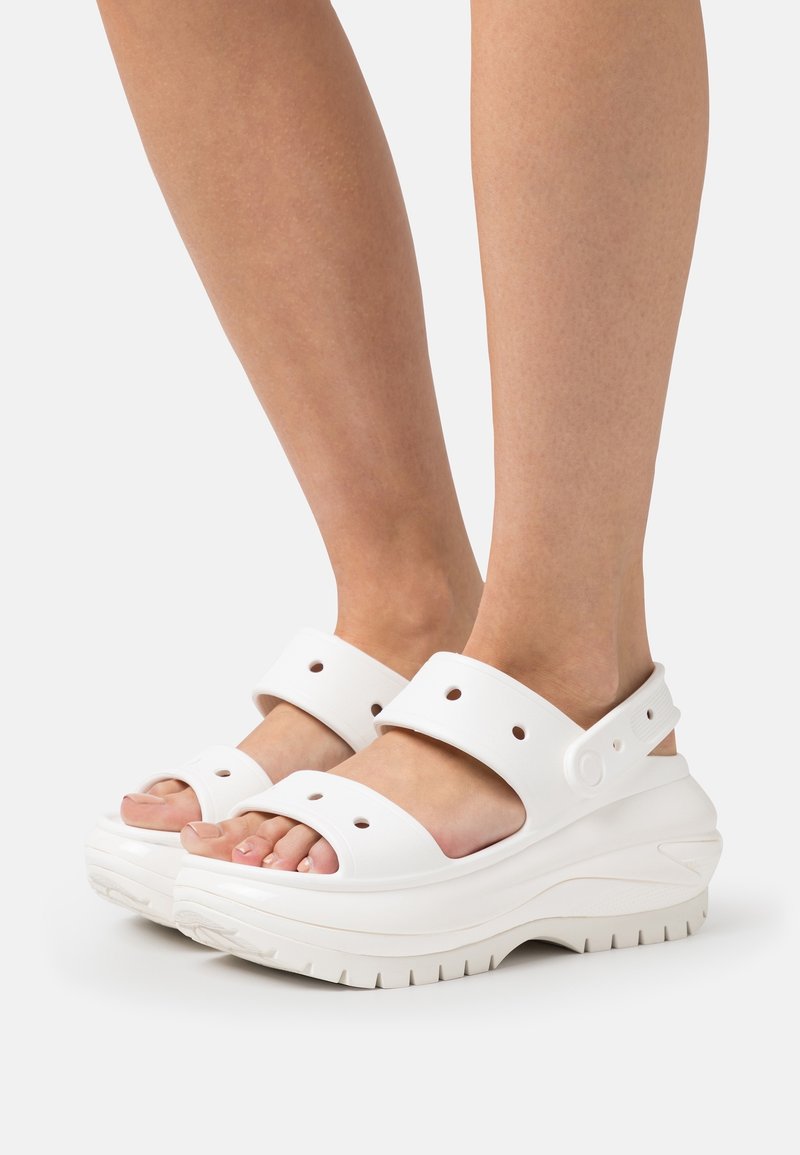 Sandales à plateforme blanches avec larges brides, trous perforés et semelle texturée. Légères, fabriquées en matériau durable avec une finition lisse.