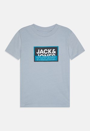 Heled sinine puuvillane T-särk, millel on ristkülikukujuline graafika, kus on suurte valgete ja mustade tähtedega "JACK&JONES", millele lisavad aktsentideks sinised ribad.