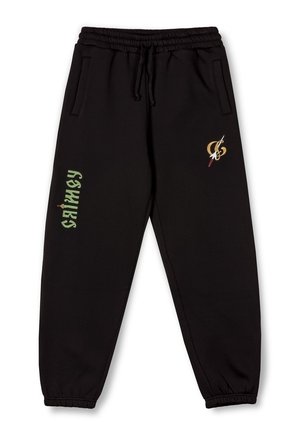Pantalones de chándal negros en tejido suave, con cintura elástica, bolsillos laterales y logos en verde y dorado en la pierna izquierda.