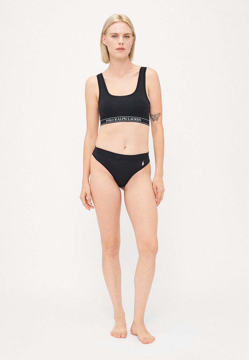 Ensemble de bikini noir en tissu lisse. Le haut présente des bretelles larges et une bande logo ; le bas a une taille basse avec un accent logo.