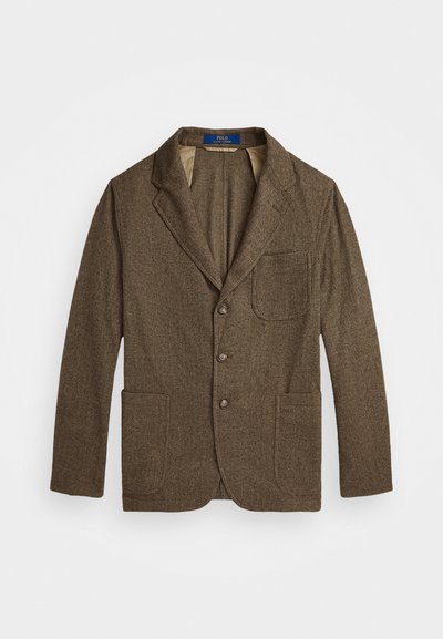 Brauner Tweed-Blazer mit Notch-Revers, zwei Vordertaschen und dreifacher Knopfverschluss. Strukturierter Stoff mit subtilm Muster. Futter im Inneren.