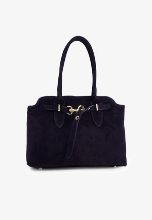 Dunkelviolette Wildleder-Handtasche mit zwei langen Griffen, einem vergoldeten Hakenverschluss und einem dekorativen Riemen quer über die Vorderseite.