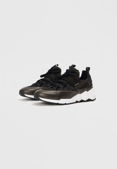 Zapatillas deportivas negras y de bronce con una parte superior texturizada, cordones gruesos y una suela blanca en zigzag. Cuenta con un tirador en el talón para facilitar su uso.