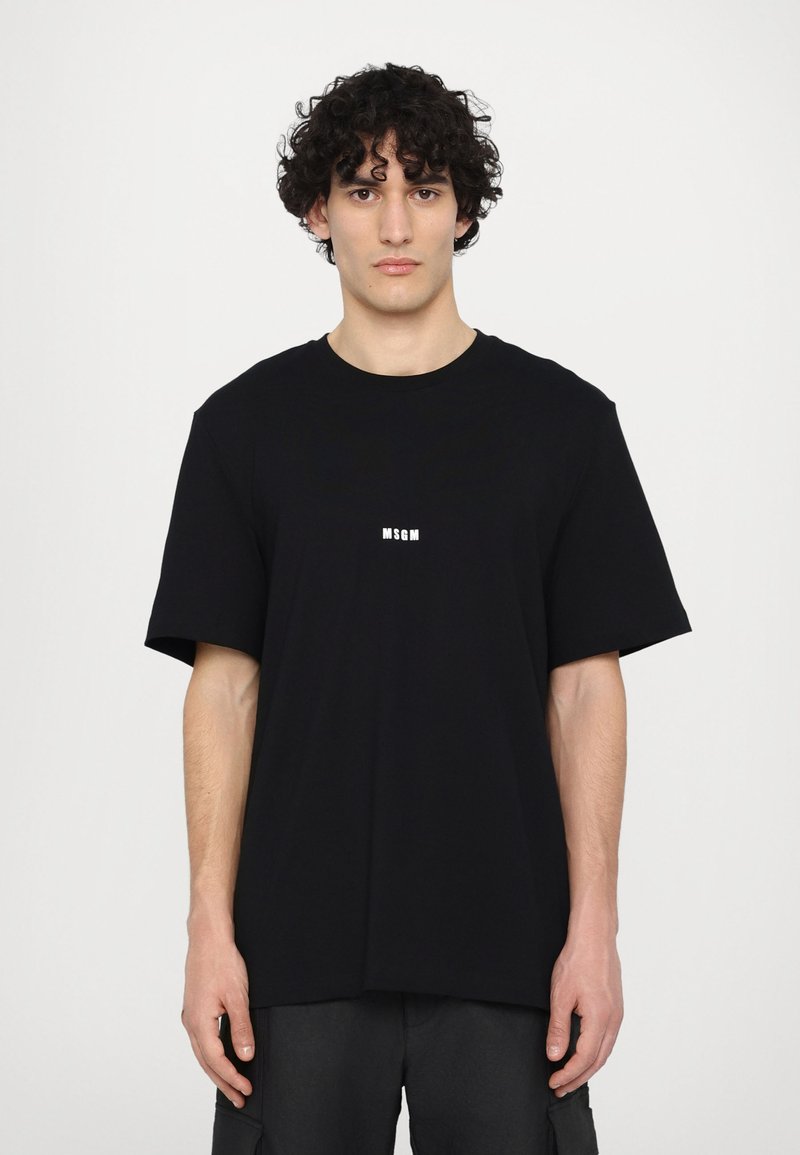 Black T-shirt made of cotton, featuring a crew neck, short sleeves, and a white logo at the center. Regular fit with a smooth texture.
