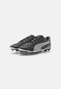 Scarpe da calcio nere con tomaia in pelle testurizzata, dettagli bianchi e suola con tacchetti. Presentano un design con lacci e colletto imbottito.