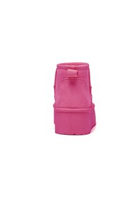 Bota de tobillo rosa con superficie texturada, puntera redonda y suela gruesa. Cuenta con una lengüeta trasera para facilitar su uso.