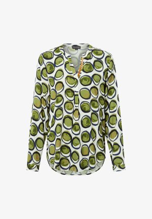 Long-sleeve blouse in white fabric with a green and black circular pattern, featuring a half-button placket and rounded hem.