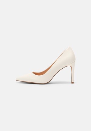 White high-heeled pump with a pointed toe and smooth texture. Features a sleek design and a slender heel with a beige inner lining.