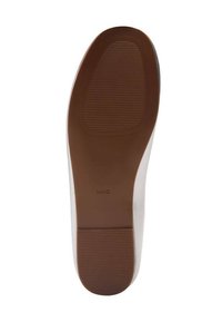 Semelle de chaussure plate avec une surface en caoutchouc brun texturé. Présente des rainures pour l'adhérence et un bord lisse qui passe à un matériau supérieur blanc.