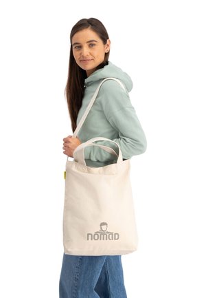 Katoenen totebag in lichtbeige met dubbele handvatten en logo. Beschikt over een stevige rechthoekige vorm met een gladde textuur en contrasterende hardware.
