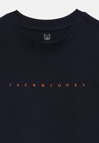 Svart bomull t-skjorte med en oransje trykt logo "JACK & JONES" på brystet og en liten hvit grafikk på halslinjen.