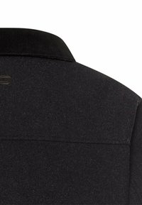 Schwarze Wollmischung Jacke mit einem Cordkragen, strukturiertem Stoff und einer Brusttasche mit dezentem Branding-Detail.