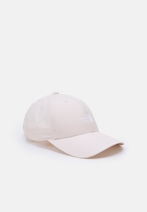 Jasnobeżowa czapka z daszkiem o zakrzywionym kształcie i przeszywanych panelach, z białym haftowanym logo "The North Face" po prawej stronie z przodu.