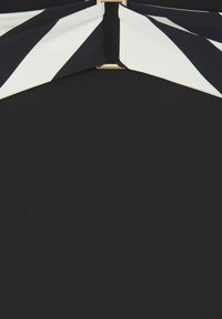 Musta mekko, jossa on leveä valkois-musta raidallinen kaulus ja keskeinen kultainen yksityiskohta. Sileä tekstuuri, vartaloa myötäilevä muotoilu.