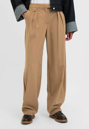 Beige plooibroek met een relaxte pasvorm, gemaakt van zachte stof. Heeft een tailleband met riemlussen en rechte pijpen.