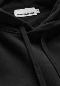 Felpa con cappuccio nera con tessuto morbido e strutturato. Presenta una tasca frontale, coulisse regolabili e un'etichetta con la scritta "ARMEDANGELS". Taglia M.