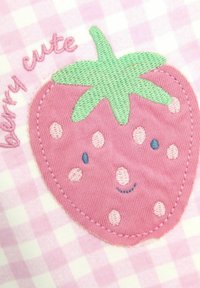 Applicazione di fragola rosa con foglia verde e pois su uno sfondo a quadretti rosa. "Berry cute" ricamato in rosa sopra il design.