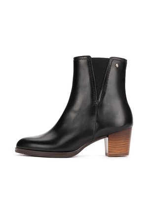 Bottine en cuir noir avec talon en bois empilé bas et panneaux latéraux élastiques pour un ajustement facile à enfiler.