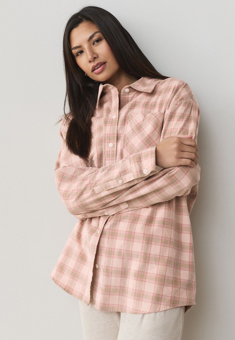 Lichtroze geruite overhemd met knopen, gemaakt van zachte stof, met een kraag, lange mouwen en een borstzak.