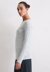 Gestreept shirt met lange mouwen in lichtblauw en crème, gemaakt van zachte stof, met een ronde halslijn en een getailleerd silhouet.