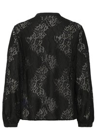 Blouse noire en dentelle à manches longues avec motifs floraux et petit col, vue de dos sur fond blanc.