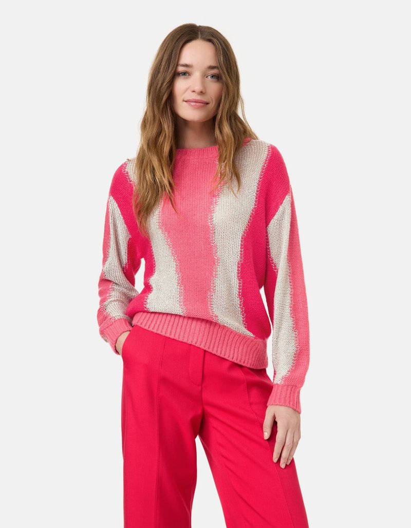 Rosa Pullover mit weißem Zickzackmuster, strukturiertem Strick sowie gerippten Bündchen und Saum, kombiniert mit leuchtend rosa Hosen.