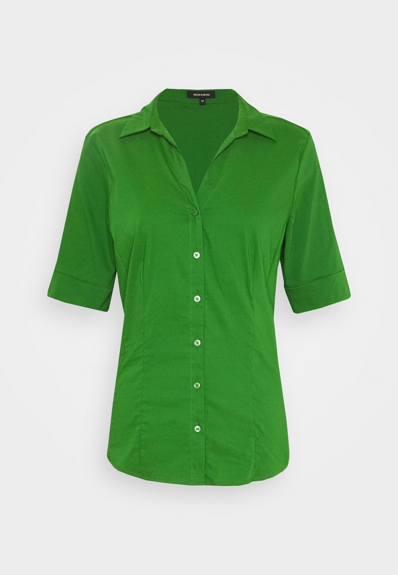 Camicia verde a maniche corte realizzata in tessuto morbido, dotata di chiusura con bottoni, colletto e sottili cuciture verticali per una vestibilità su misura.