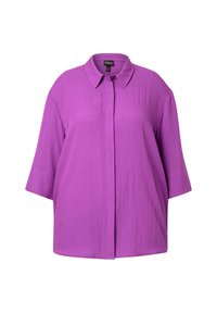 Camicia viola oversize con colletto, maniche corte e chiusura frontale con bottoni. Realizzata in un tessuto leggero e texture.