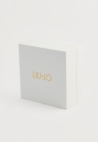 Biela textúrovaná obdĺžniková krabička s centrálne umiestneným zlatým logom "LIU JO" na prednej strane, umiestnená na jednoduchom bielom pozadí.
