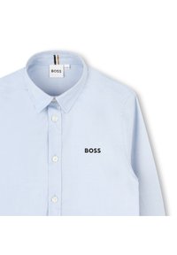 Šviesiai mėlynas mygtukų laikymo marškinys, pagamintas iš lygios medvilnės audinio. Turi klasikį apykaklę, siuvinėtus akcentus ir juodą "BOSS" logotipą ant krūtinės.