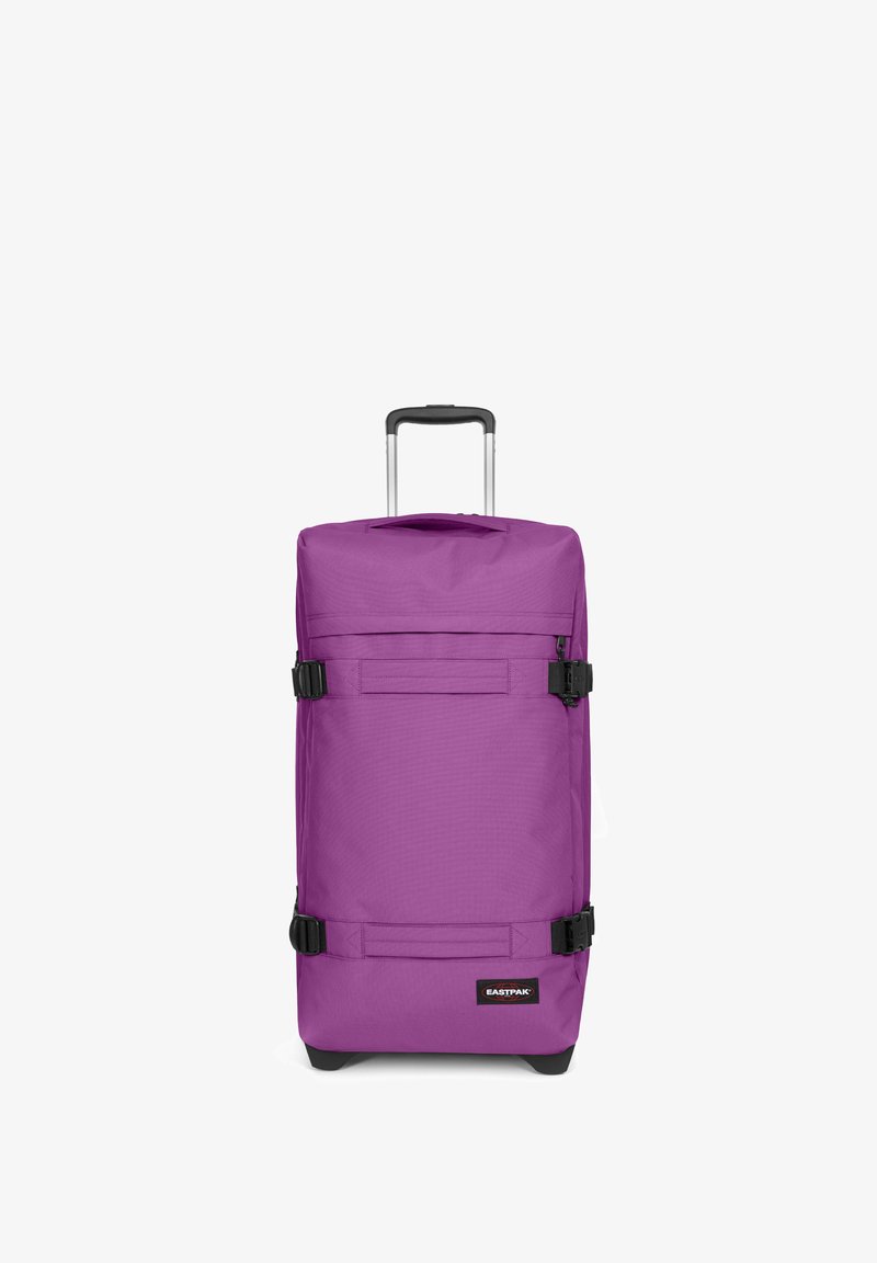 Fialový cestovní kufr s texturovaným povrchem, nastavitelnými popruhy, horním madlem a černými koly. Štítek zní "EASTPAK."