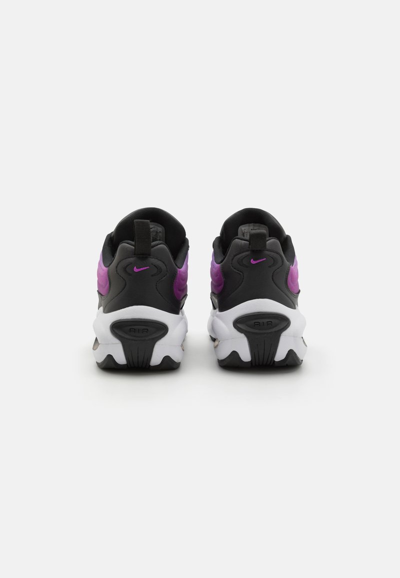 Sneaker Nike neri e viola con suola bianca spessa, superficie liscia, forma arrotondata e logo distintivo sul retro.