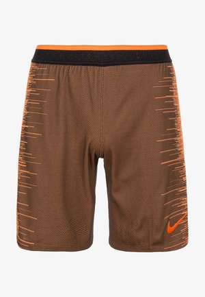 Brązowe, teksturowane spodenki sportowe z czarno-pomarańczowym pasem, pomarańczowymi paskami po bokach oraz pomarańczowym logo Nike na prawej nodze.