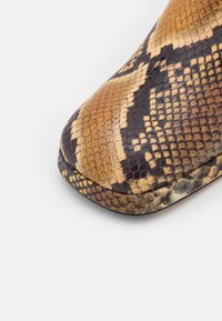 Buty skórzane ze wzorem w węża, zaokrąglony nos, z łuskami w odcieniach brązu, beżu i czerni oraz gładkim, matowym wykończeniem.