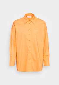 Camisa de manga longa laranja feita de algodão, com gola pontuda, botão frontal e um bolso no lado esquerdo do peito.