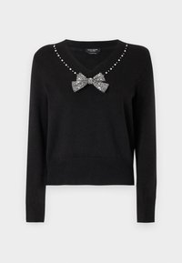 Czarny sweter z dekoltem w serek, ozdobiony małymi srebrnymi ćwiekami oraz kokardą z akcentami z kryształków na środku. Mankiety i dół swetra są ściągane.