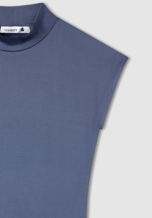 Top a maniche corte in tessuto blu testurizzato e liscio con scollatura alta, caratterizzato da un design pulito e minimalista senza hardware visibile.