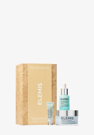 Ensemble de soins Elemis Pro-Collagen avec compte-gouttes de sérum, tube de crème pour les yeux et pot de crème marine SPF 30 à côté d’une boîte beige à motif floral.
