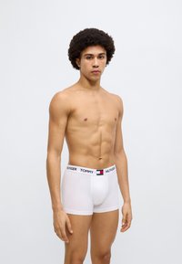 Λευκά μπόξερ από βαμβάκι με μαύρη ζώνη μέσης που φέρει το λογότυπο "TOMMY HILFIGER" και λεπτομέρειες σε χρώματα.